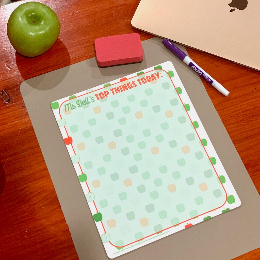 Get organised with this personalised mini-whiteboard featuring Haluna Happy Names 'Apples' design background and headed with name and heading of your choice, this one says 'Ms Bell's Top Things Today'. On a desk with apple, eraser, pen and an Apple laptop (of course).