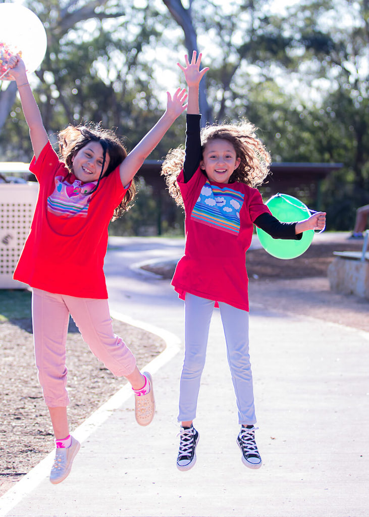 Pick me! Haluna Happy Names colourful tshirts personalised with Arabic option are designed for confidence and joy as these two jumping happy girls in their 'In the Sky' and 'Jewels in my Heart' original t-shirts are showing.