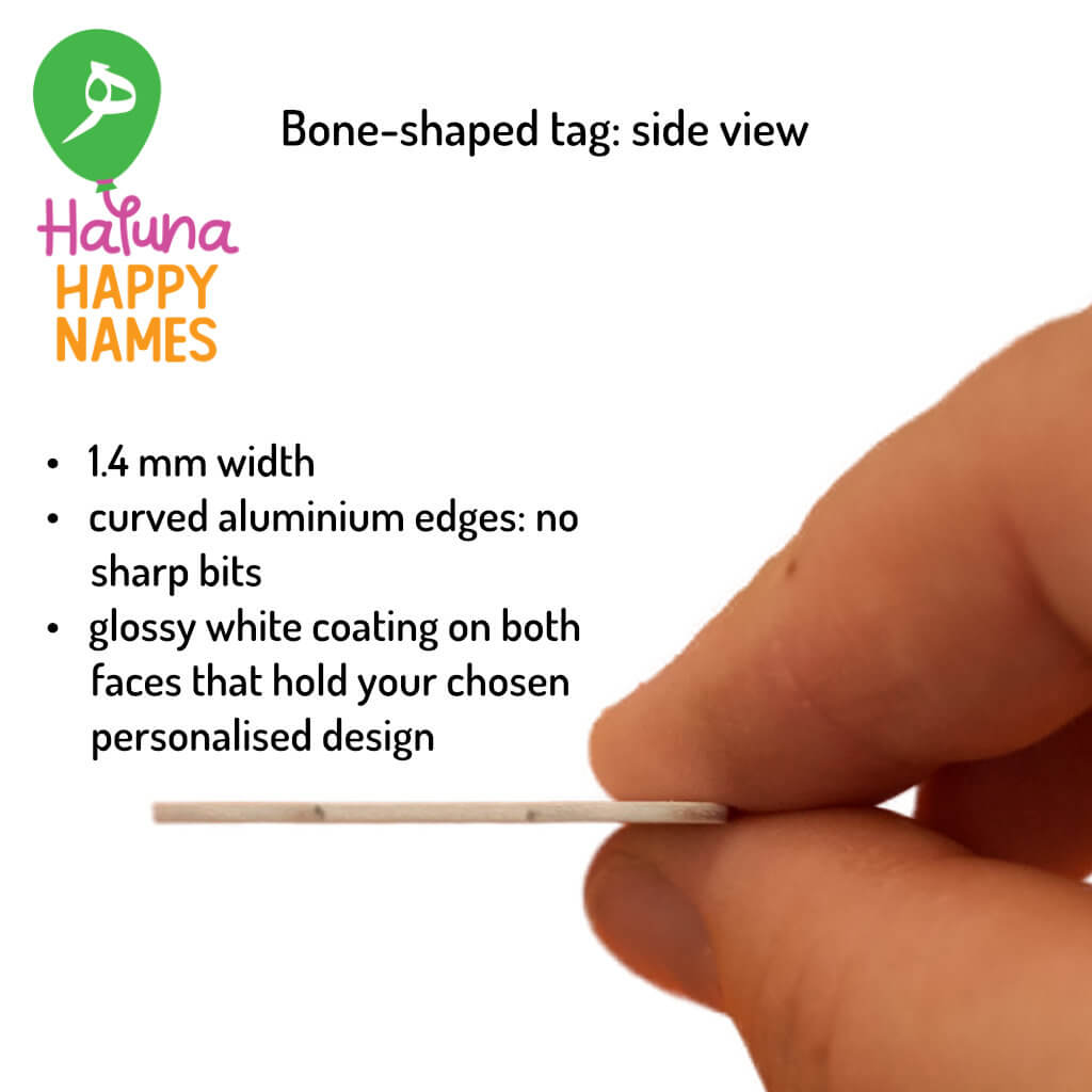 A hand holds a bone shaped aluminium ID tag sideways on against white background. Haluna Happy Names balloon logo is in top left corner.